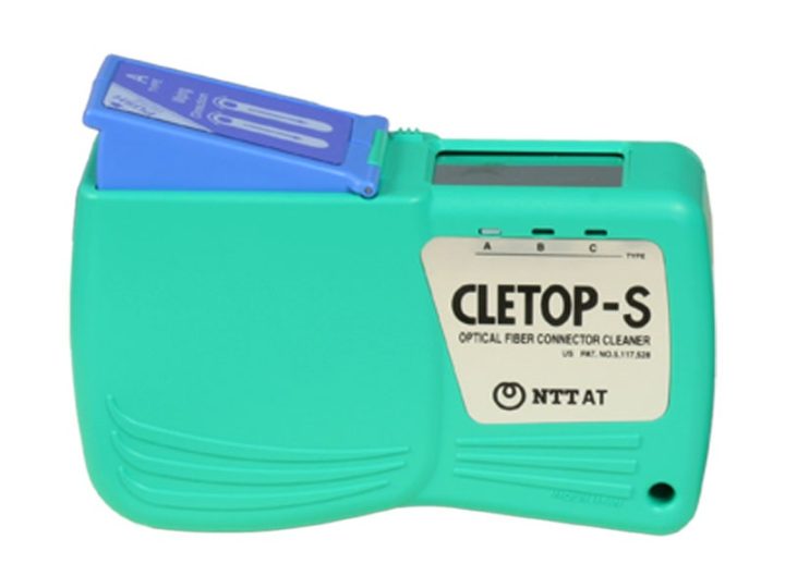 Green palm-sized cassette cleaner on white, labelled 'CLETOP-S OPTICAL FIBER CONNECTOR CLEANER / NTT AT', with the blue drop-in tape cassette raised.
